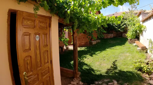 Puerta de madera al jardín con césped